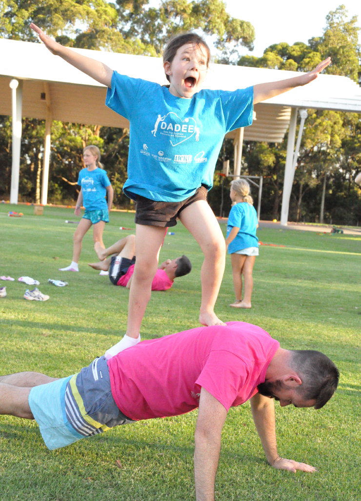 Girl standing on dads back